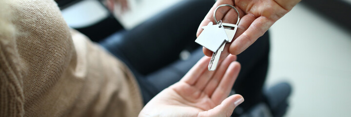 A woman in a wheelchair receives the keys to the house from the hands of a man. Active employment...