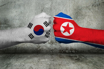 3D-Illustration of a Conflict Concept between the Republic of Korea (South Korea) and the Democratic People's Republic of Korea (North Korea) with two opposing fists in front of a wall. 3D-Rendering