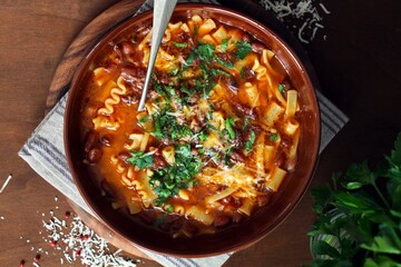 Pasta and beans soup with parmesan cheese. Top view with copy space. Vegetarian and vegan food.