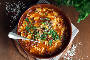 Pasta and beans soup with parmesan cheese. Top view with copy space. Vegetarian and vegan food.