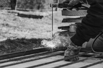welding of a metal framework, works take place on the street, the process of welding of metal is visible in a close-up.