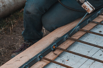 A man welds a metal frame to build an aviary, welding metal close up.