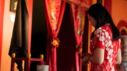 asian girl praying and wishing a happy chinese new year at vihara