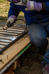 A man welds a metal frame to build an aviary, welding metal close up.