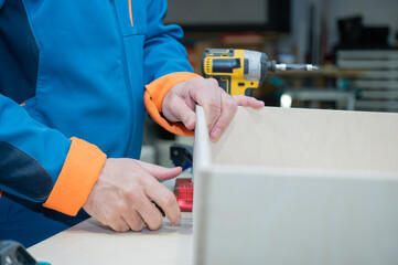 Closed up of the hands of a Caucasian craftsman holding a handmade furniture.