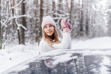 young girl in winter forest smiles and looks up in car