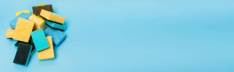 High angle view of colorful sponges on blue background, banner