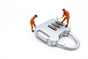 Miniature people: Worker hacking in padlock security. concept for data security breach, risk and hacker attack.