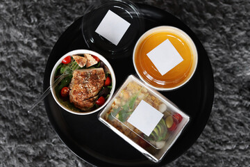 Lunch boxes with food ready for work or school, pre-cooking or diet. Pumpkin soup, baked chicken with tomatoes and scrambled eggs with avocado. 
Healthy food delivery.