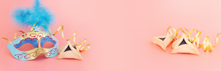 Purim celebration concept (jewish carnival holiday) over pastel pink background