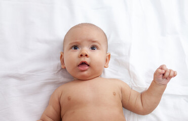 Baby portrait, newborn baby girl lies on bed