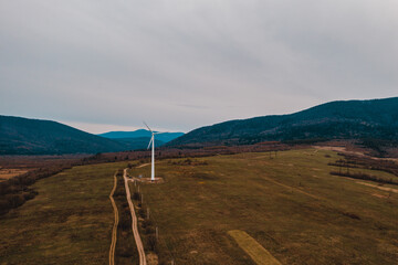 View of a wind turbine in the mountains in the background, Alternative energy, Ukrainian windmill in a field in the Carpathian region.