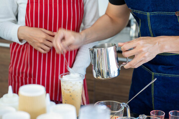Asian coffee barista employee wearing red apron working in the coffee shop to reopen after virus pandemic