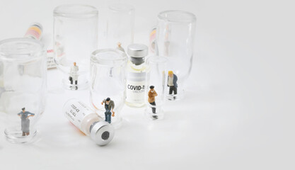 Group of people (figurine) standing in empty  vaccine glass vials.Coronavirus covid-19 vaccine development to fight against coronavirus pandemic..Healthcare And Medical concept.