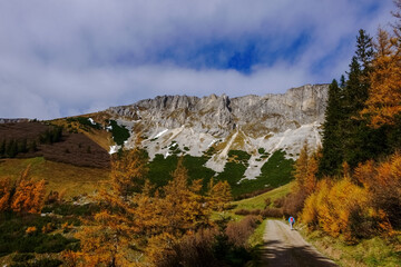 dirt road with a hiker in a colorful mountain valley