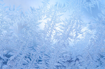 Frost snowflakes on window glass texture background