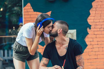 Happy loving couple with headphones sharing music in cafe