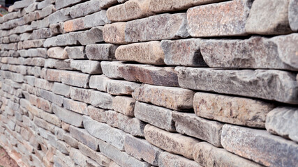 A wall of flat stones. Retaining Wall. artistic sandstone wall texture background patterns.