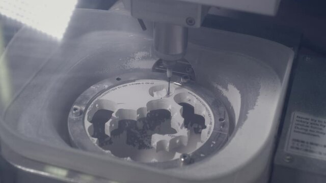 A professional CNC machine automatically creates a tooth prosthesis. The drill grinds an imitation of a ceramic jaw. Advanced technology in dentistry. Dental implant production.