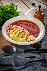Red borscht soup in bowl.