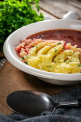 Red borscht soup in bowl.