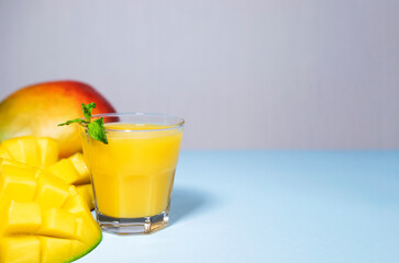 Mango Shake on Blue Background. Healthy Drinking Vitamin Smoothie. Fresh Tropical Mango Fruit Juice. Space for Text, Copyspace. Dieting Food. Colourful Background