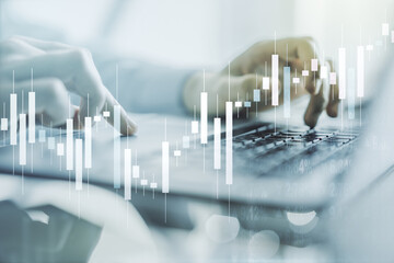 Multi exposure of abstract creative financial graph with hand typing on laptop on background, forex...