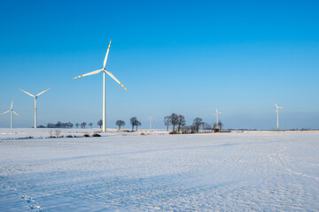 Fototapeta na wymiar Windmills for electric power production. Winter landscape in northern Poland. Europe