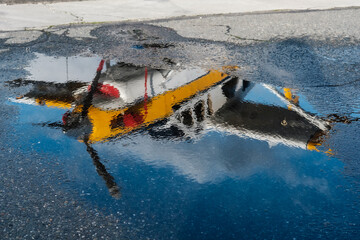 The reflection of a seaplane in a puddle on a blue sky day