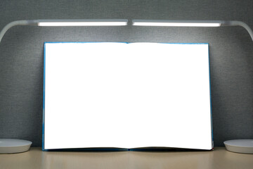 An open book with blank pages lies on a wooden table. On both sides of the book are two table...