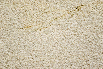 Apply sand rubbing plaster to masonry on concrete. Scratched and cracked dirty weathered sand textured plaster surface texture.