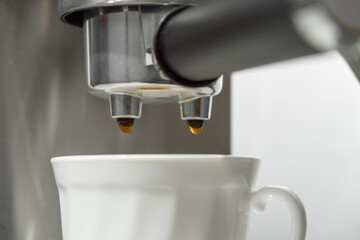 Coffee machine portafilter close-up during the process of pouring coffee into a cup