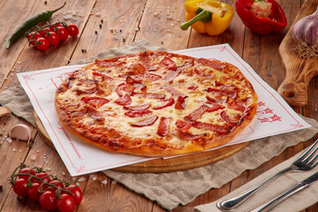 Pizza with meat, vegetables and mushrooms, wooden background