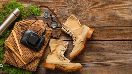 Composition with items and clothes for hiking on wooden background