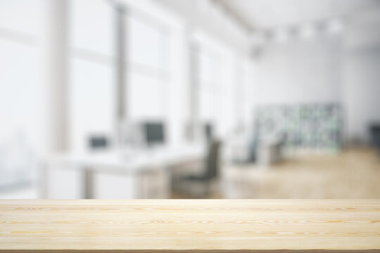 Blank tabletop made of wooden planks with light contemporary furnished office on background, mockup