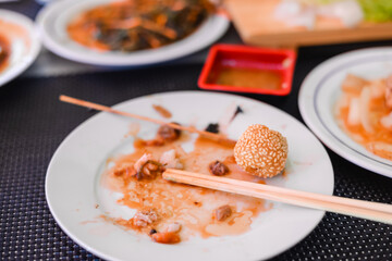 left over food on wooden table with chopsticks