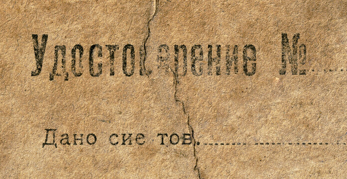 Macro photo of the old wethered yellowed certificate of the employee of the Soviet secret police of the 20s of the 20th century. Translation: the certificate is given to comrade...