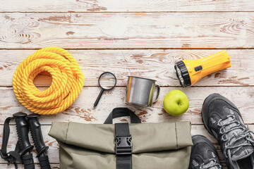 Items and shoes for hiking on wooden background