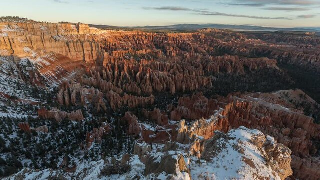 Time lapse sunrise over beautiful Bryce Canyon, travel USA concept. Beautiful orange peaks covered with snow highlighted by the morning light. Nature landscape with red cliffs background. Winter trip