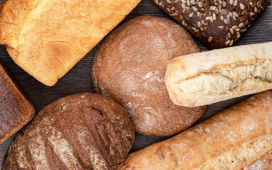 Top view of several loaves of bread over a wooden background.