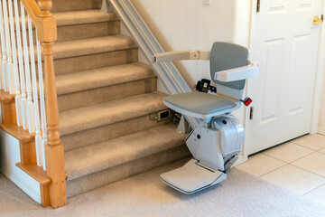 An electric, motorized chair life for persons with disabilities on a carpeted staircase in a residential home. - Powered by Adobe