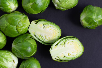 Fresh Brussels sprouts flat lay on black background