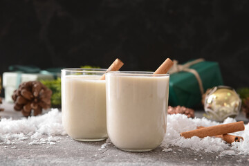 Tasty banana smoothie with cinnamon in glasses on gray background