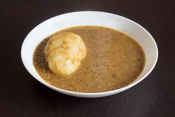 A plate of lentils with potato on a wooden table. Legumes and homemade food recipes.