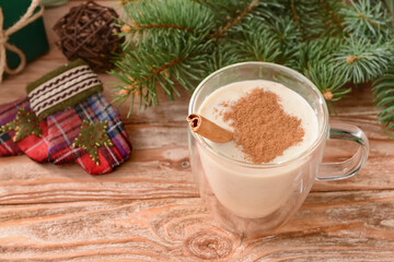 Obraz na płótnie Canvas Tasty milkshake with cinnamon in cup on wooden background