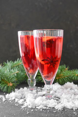 Tasty mulled wine with cinnamon in glasses on dark background