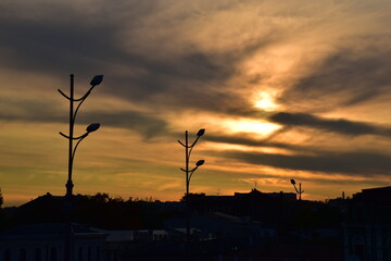 Street lights silhouette at sunset, evening city landscape, no electricity