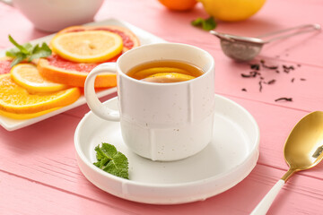 Cup of hot tea with lemon and grapefruit on wooden background