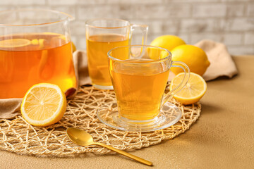 Cups of hot tea with lemon on color background