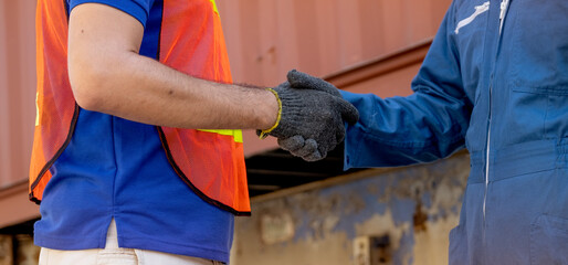 Close up hand shaking of cargo container worker or engineer in workplace area. Business Logistics...